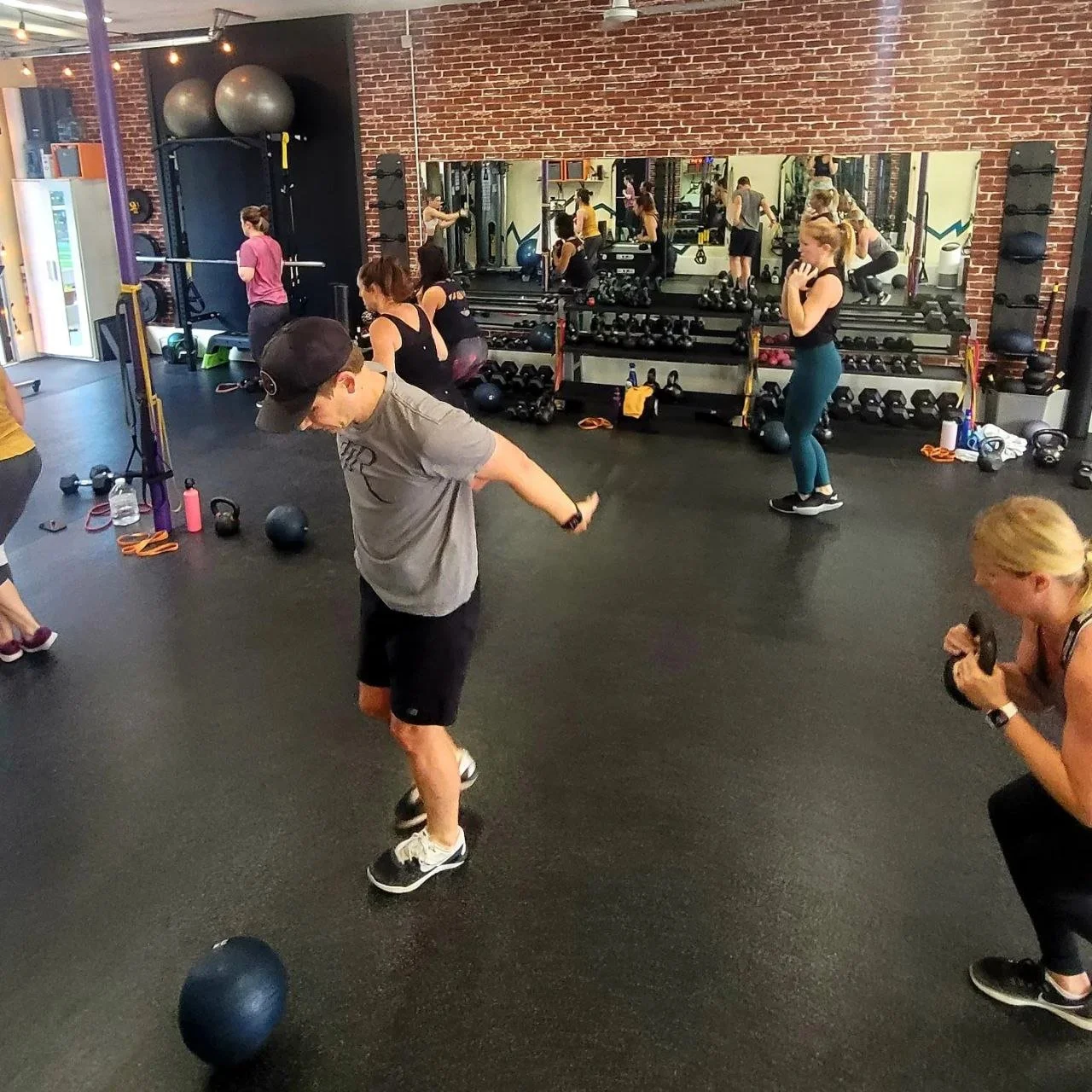 The gym floor at Efficient Working Bodies with racks, mirrors and cardio equipment